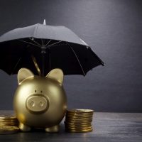 Gold Piggy bank with umbrella concept for finance insurance, protection, safe investment or banking