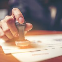 Close-up hand stamping of businessman for signing approval on documents , business concept Close-up hand stamping of businessman for signing approval on documents , business concept