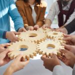 Team of people connecting gear wheels. Group of men and women joining cog wheels. Business, teamwork, effective work, project management, innovation, integration concepts Team of people connecting gear wheels. Group of men and women joining cog wheels. Business, teamwork, effective work, project management, innovation, integration concepts
